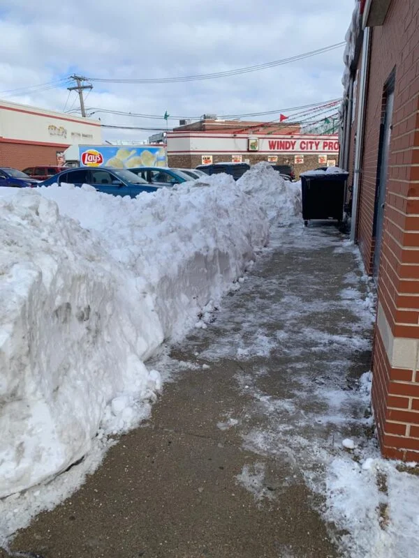 Commercial snow removal with cleared sidewalk path in Chicago winter